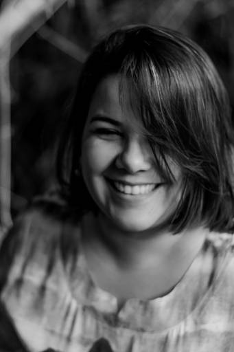 foto em preto e branco de mulher sorrindo com o cabelo no rosto