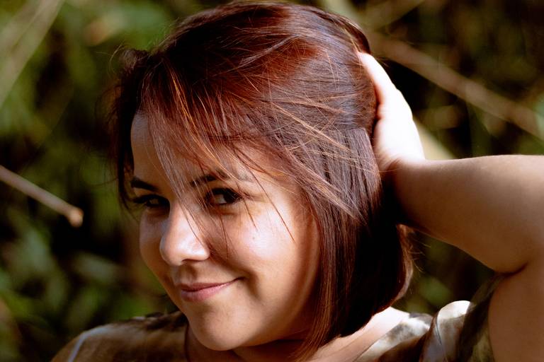 imagem de rosto de mulher olhando de canto de olho segurando o cabelo