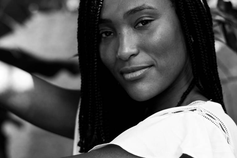 foto em preto e branco de mulher negra séria em sessão de fotos em casa