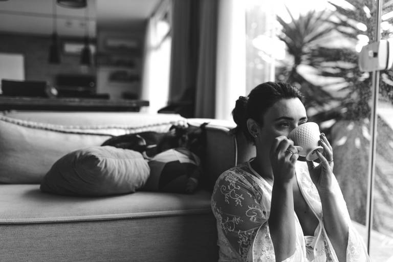 mulher em casa sentada no chão tomando chá