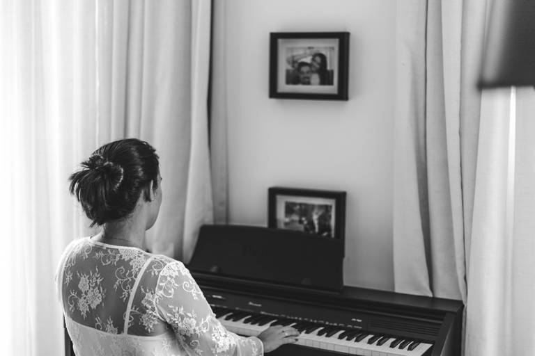 imagem em preto e branco de mulher tocando piano em casa
