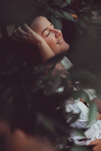 foto de mulher com mão no rosto atrás de plantas