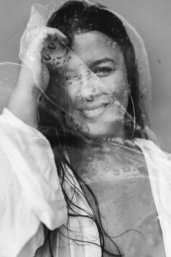 foto em preto e branco de rosto de mulher molhada com sobreposição de folha 