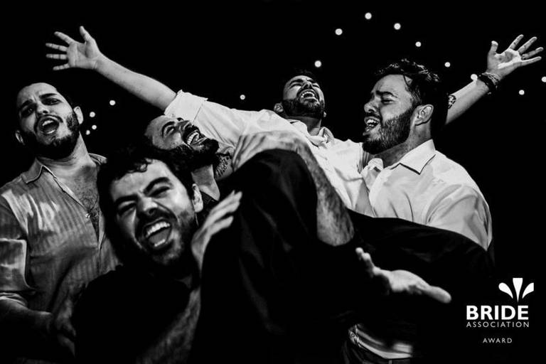 festa de casamento com padrinhos carregando o noivo no colo