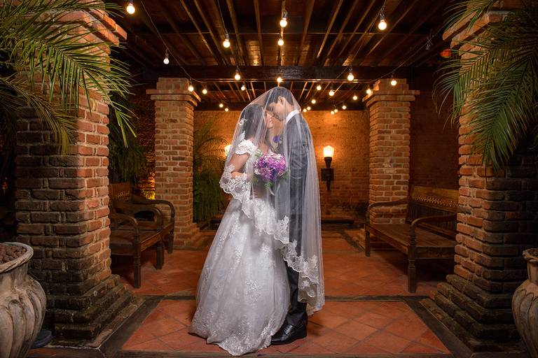 noivos cobertos pelo véu da noiva em ambiente rústico com coloração laranja para marrom, iluminação rambrandt após o casamento, Niterói, Rio de Janeiro, RJ