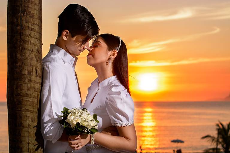 noivos namorando ao por do sol, com um lindo sol ao fundo refletindo na agua da praia durante o pré wedding, Niterói, Rio de Janeiro, RJ