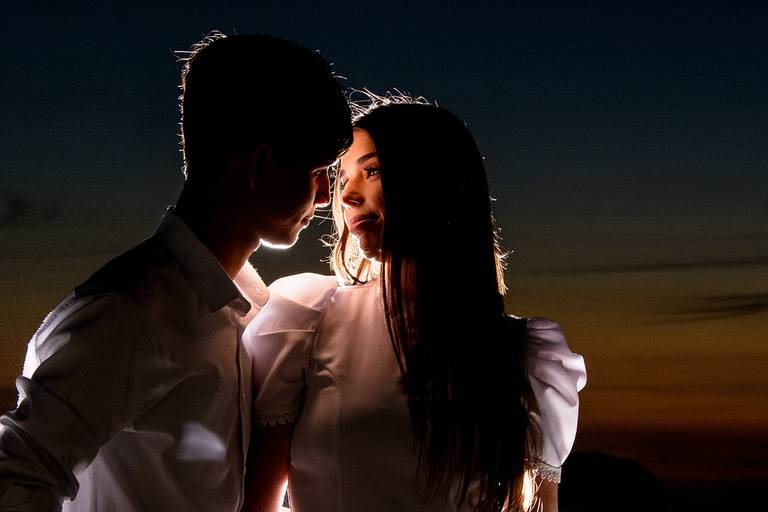 noivos se olhando de perto com luz direcionada para o rosto com o fundo escuro durante o pré wedding, Niterói, Rio de Janeiro, RJ