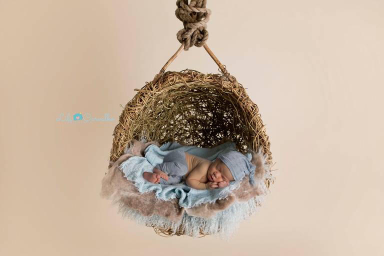 fotografia de bebê em cesto pendurado