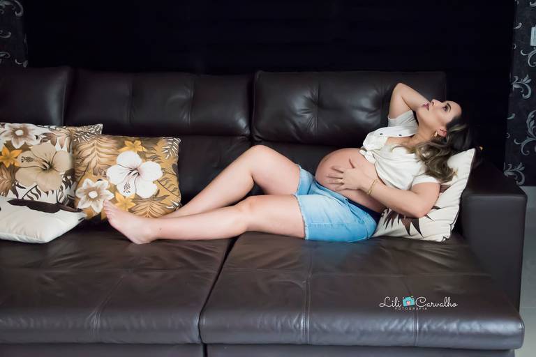 gestante deitada em sofá de sua casa, em Maringá 