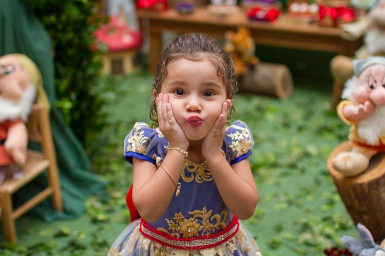 Manu com as mãozinhas na bochecha fazendo bico