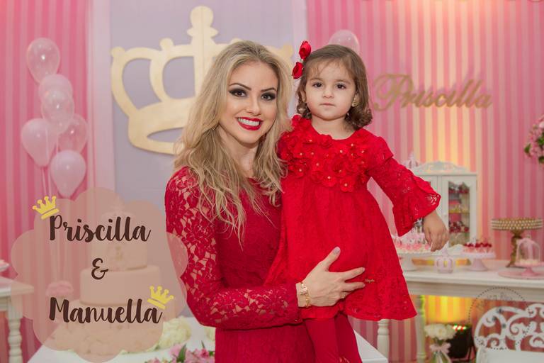 Priscilla e Manuella vestidas de vermelho, em frente a decoração da sua festa 