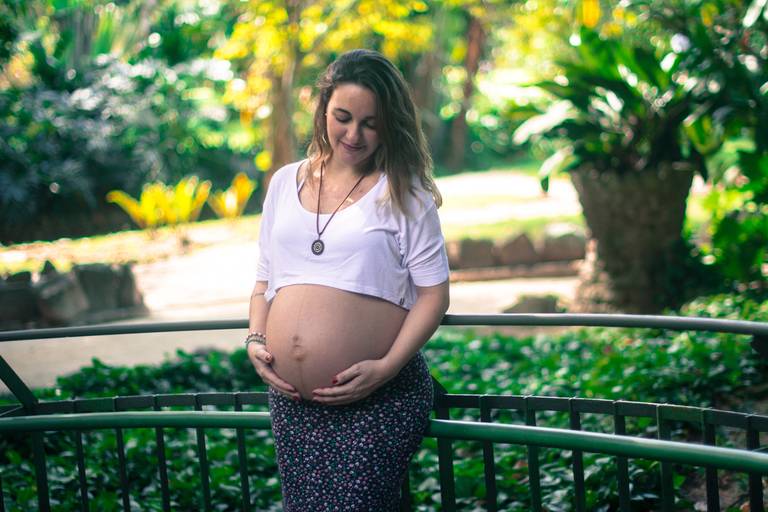 Grávida segurando a barriga no Jardim Botânico