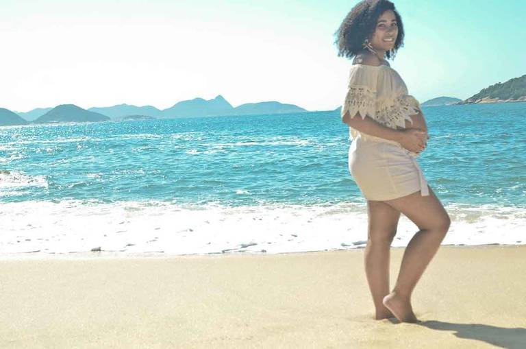 Gestante sorrindo em frente ao mar  na Praia Vermelha no Rio de Janeiro
