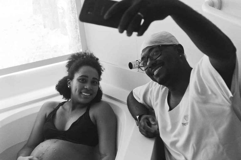 Casal Grávido na Banheira de Hidro Massagem fazendo uma selfie Durante Um Parto Humanizado na Perinatal da Barra da Tijuca no Rio de Janeiro