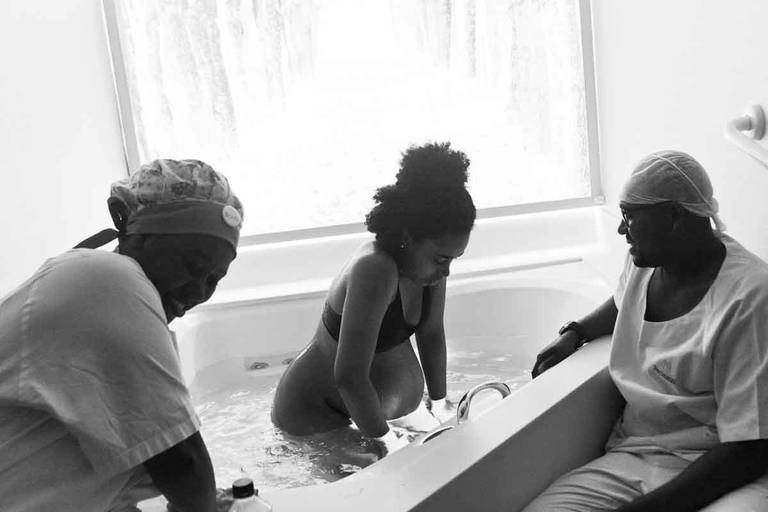Casal Grávido com a Doula na Banheira de Hidro Massagem Durante Um Parto Humanizado na Perinatal da Barra da Tijuca no Rio de Janeiro