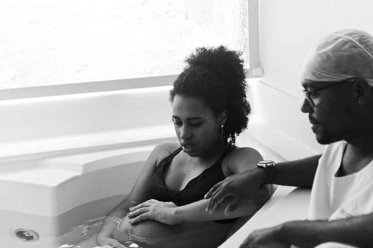 Casal Grávido na Banheira de Hidro Massagem Durante Um Parto Humanizado na Perinatal da Barra da Tijuca no Rio de Janeiro