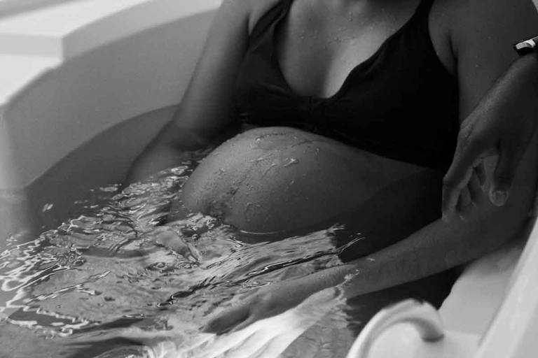 Close Up da Barriga da Gestante na Banheira de Hidro Massagem Durante Um Parto Humanizado na Perinatal da Barra da Tijuca no Rio de Janeiro