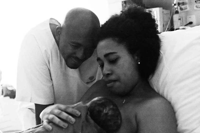 Casal Olha apaixonado para a filha nos braços da mãe pela primeira vez durante um Parto Humanizado na Perinatal da Barra da Tijuca no Rio de Janeiro