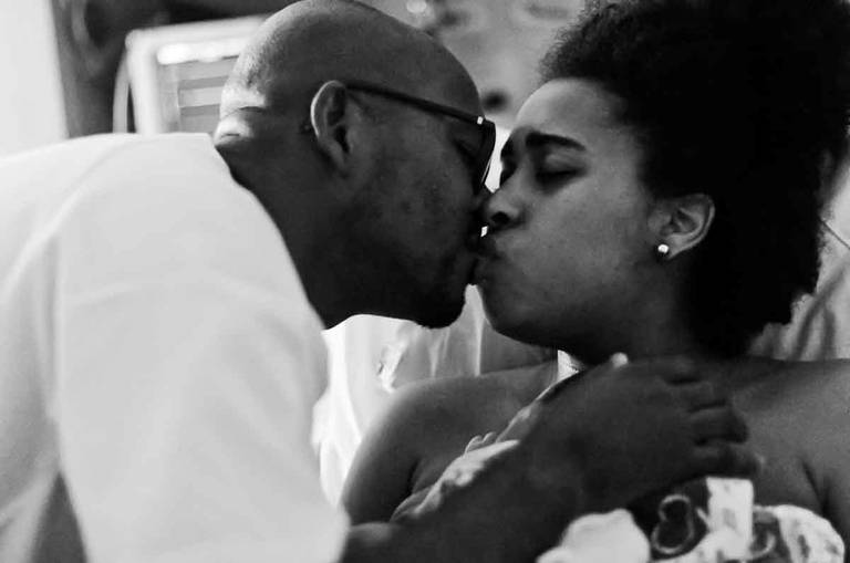 Casal se beija com a filha no colo da mãe durante um parto Humanizado na Perinatal da Barra da Tijuca no Rio de Janeiro