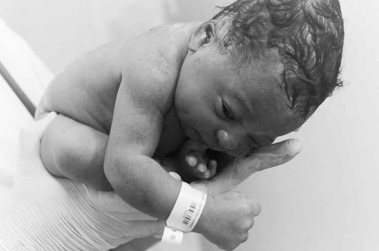 Bebê sendo segurado nas mãos de uma enfermeira durante Um Parto Humanizado na Perinatal da Barra da Tijuca no Rio de Janeiro