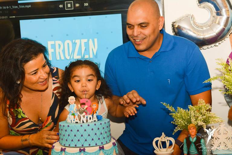 Menina  assoprando a vela do seu bolo temático de Frozen em festa infantil de aniversário no Espoleta de Laranjeiras no Rio de Janeiro