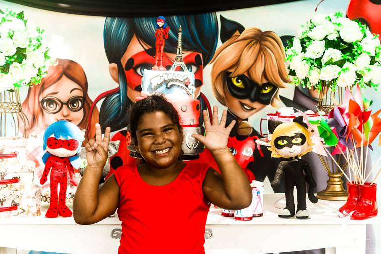 Criança Feliz Comemorando Seu 9 Anos em frente a decoração da Lady Bug em Sua Festa Infantil