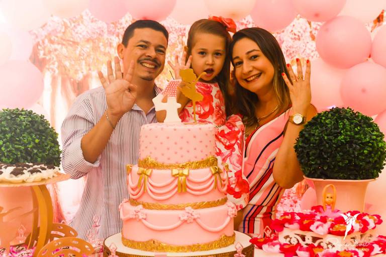 Menina com os pais mostrando que está completando 4 anos em sua festa de aniversário infantil com o tema bailarina