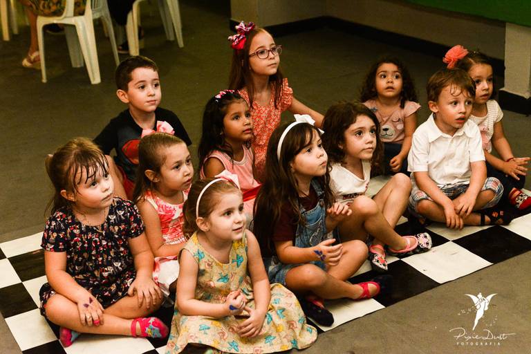 Crianças sentadas no chão durante uma animação em uma festa de aniversário infantil no Rio de Janeiro