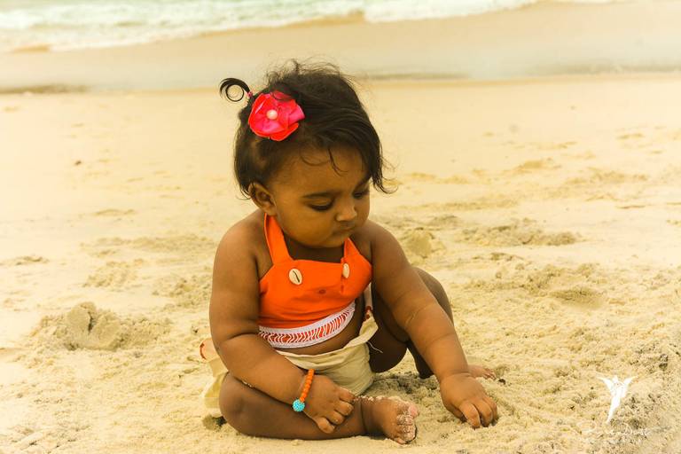 Bebê vestida de Moana na praia em ensaio temático
