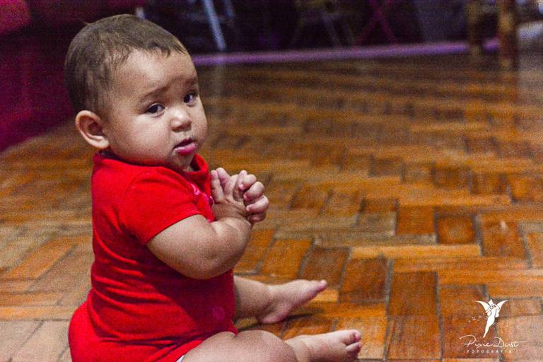 Bebê emburrada sentada no chão