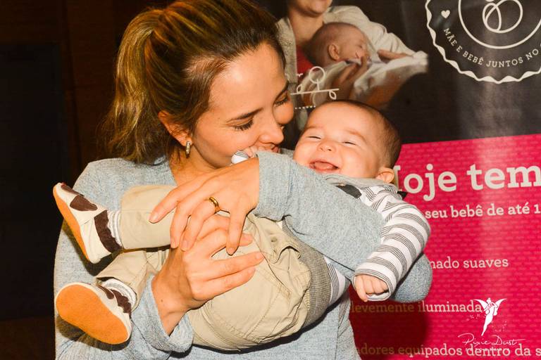 Bebê gargalhando no colo da mamãe no Cine Materna