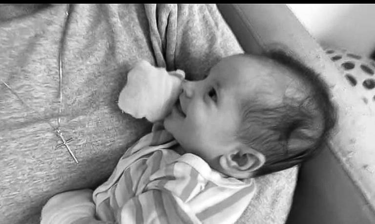 Bebê sorrindo no colo da mãe