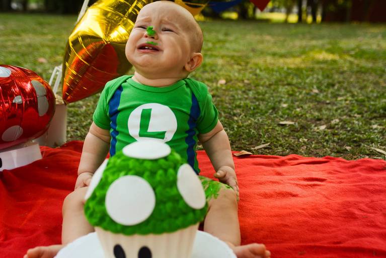 Bebê de um aninho vestido de Luigi do Super Mario Bros em Smash The Cake no Aterro do Flamengo no Rio de Janeiro
