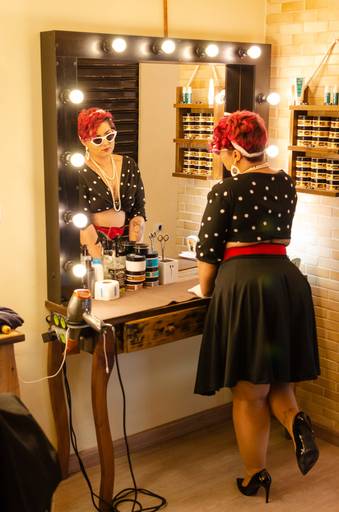 Ensaio sensual  PinUp numa barbearia com saia preta e cropped de bolinha.