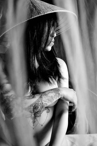 Ensaio fotográfico sensual feminino com chapéu em preto e branco.