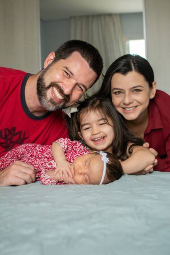 pai, mãe e filhas posando para foto