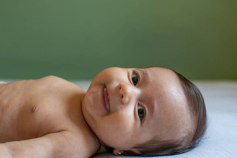 bebe deitado e sorrindo