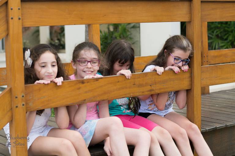 quatro meninas sentadas em uma ponte