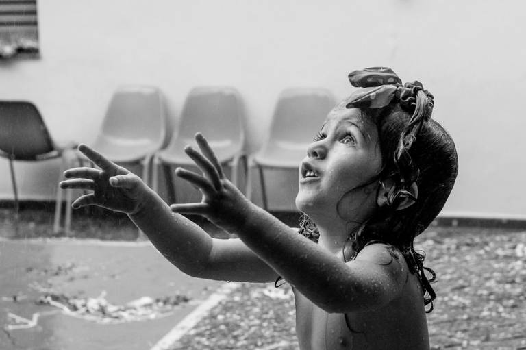 criança brincando na chuva