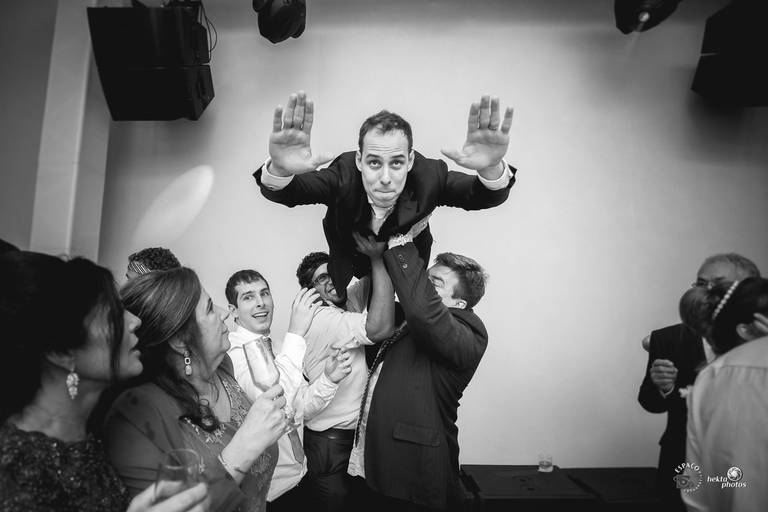 noivo sendo levantado pelos padrinhos