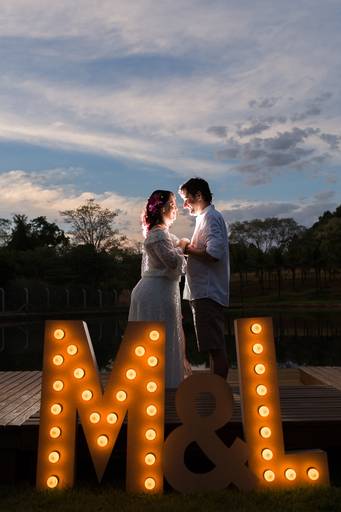 foto de ensaio de casal com letras de lâmpadas