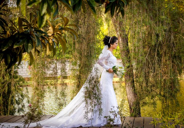 noivos gleison e vilma juntos debaixo de flores durante pós casamento no espaço shangrilá, coqueiros ao fundo, fotografia de casamento criativo