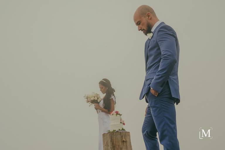 Noiva olhando para seu buquê no Topo do Rio do Rastro Eco Resort Elopement nas Nuvens InComum Eventos