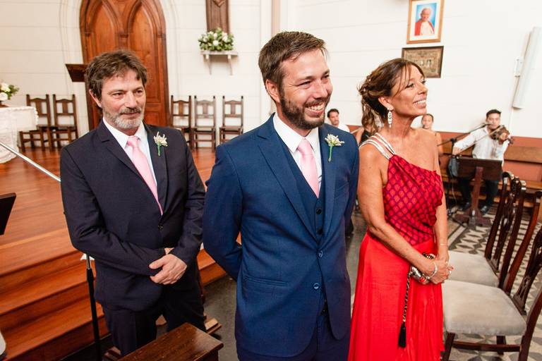 El novio con sus padres aguardan a la novia en el altar.