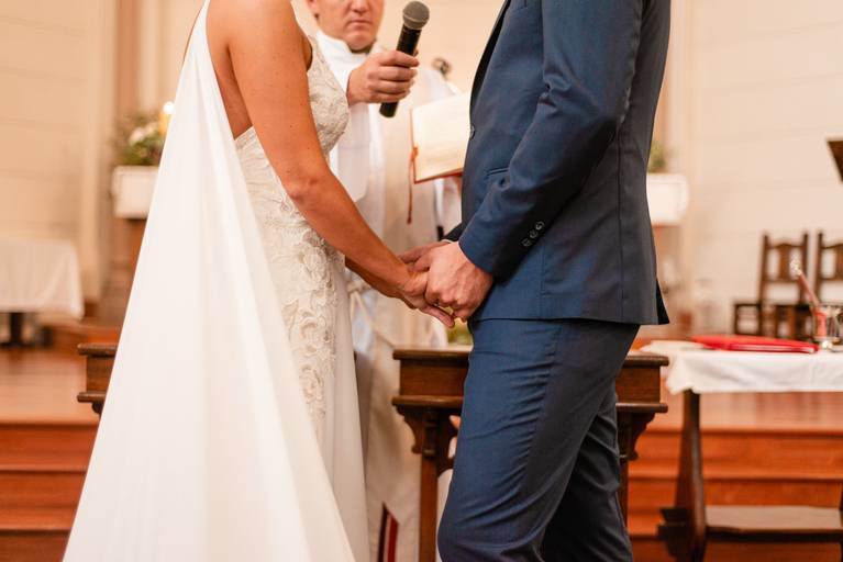 Detalle de los novios, tomados de la mano.