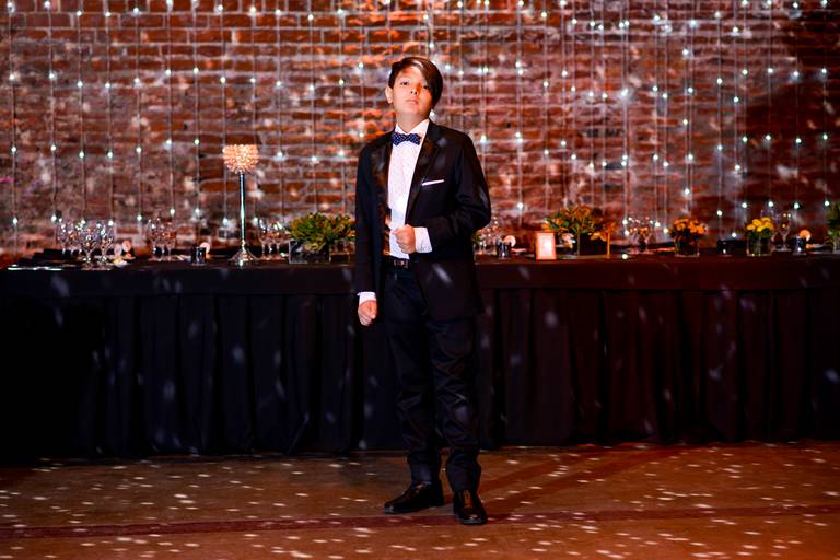 Retrato niño de moño delante de la mesa principal, bar mitzvah. Salón El Garage, San Telmo, CABA. Marcos Pasquare fotógrafo de bar mitzvah