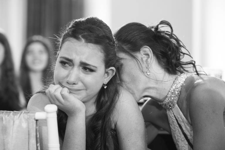 Foto de la hermana del anfitrión que llora y su mamá la consuela con un beso en Colony Eventos, Flores, CABA. Marcos Pasquare fotógrafo de bar mitzvah