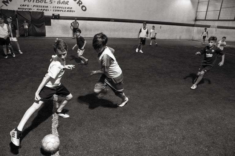 Partido de fútbol. Retrato infantil en exterior día de lluvia con una piscina de fondo. Marcos Pasquare fotografía de