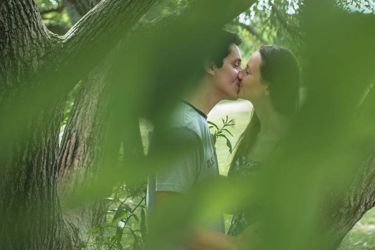 Sesión pre boda en la Costanera Sur, CABA. Los novios entre las hojas se besan. Reserva ecológica. Marcos Pasquare Fotógrafo de Bodas.