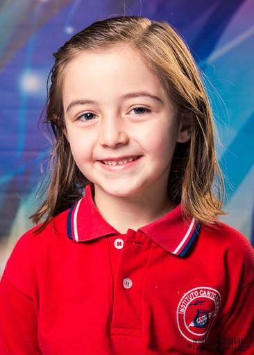 Niña de primer grado rubia de ojos celestes en su primer foto escolar. hermoso retrato. Insituto Canto a la vida. Marcos Pasquare Fotografía escolar.